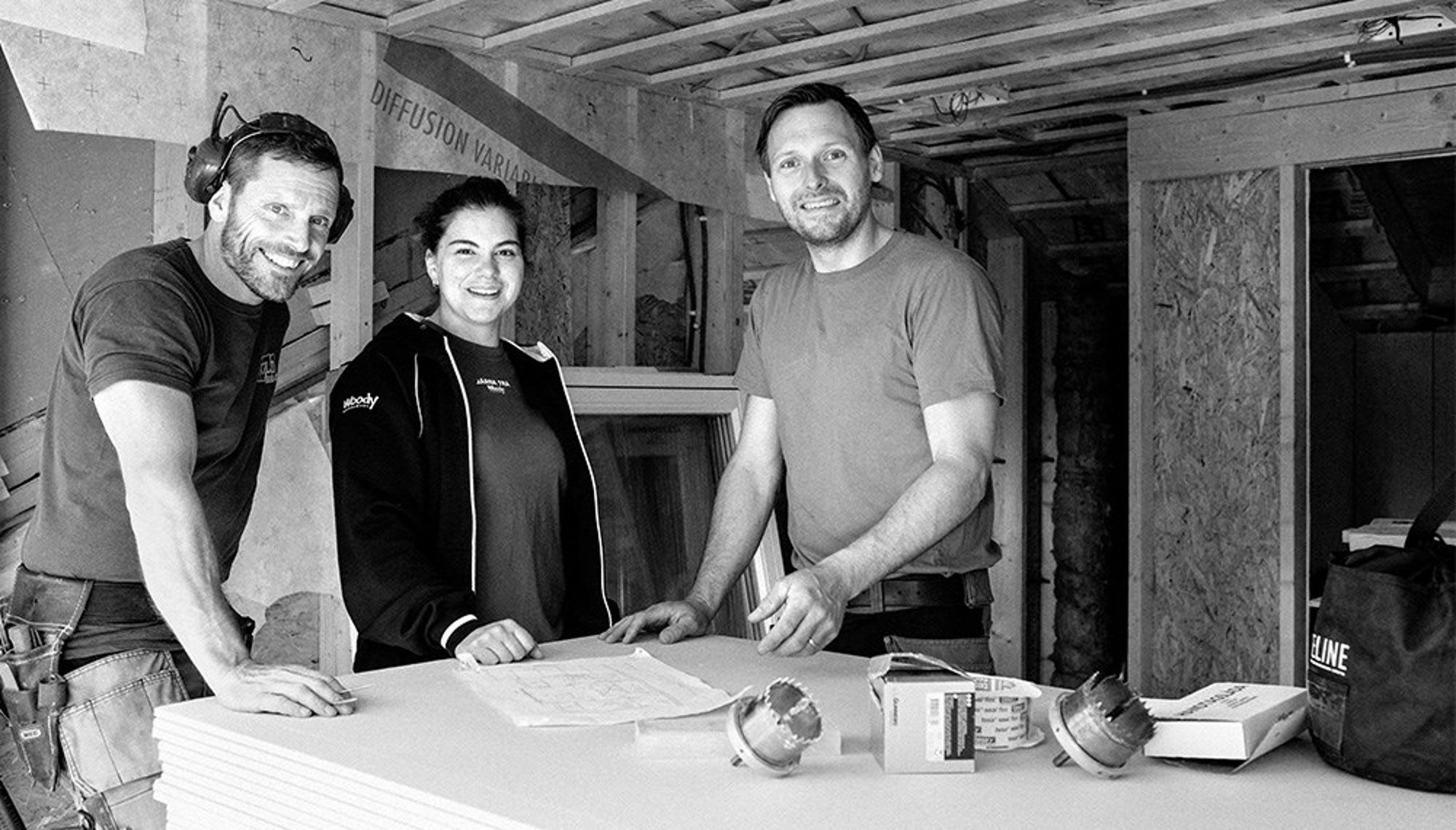 nomenu Svartvit bild på tre personer från Woodys Bygghandel 