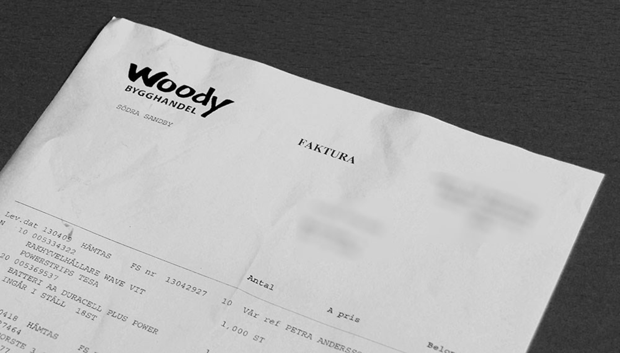 nomenu Svartvit bild på en samlingsfaktura från Woodys Bygghandel 