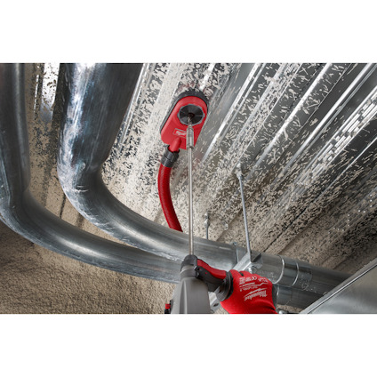 Rörledningar och metallslangar installerade på ett plåtklätt tak; två röda verktyg syns.