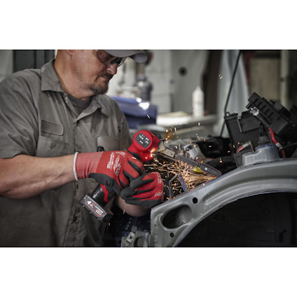 Person slipar metall med en trådlös vinkelslip, gnistor flyger. Bär skyddsglasögon, keps och röda handskar.