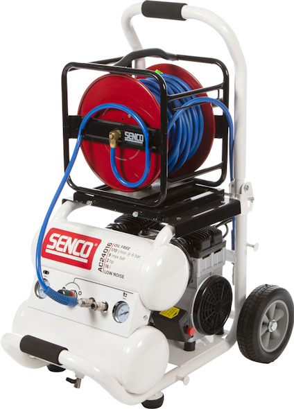 Luftkompressor på vagn med slangvinda och blå slang, märkt "SENCO".