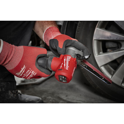 Person med röda handskar använder en röd slipmaskin nära ett bilhjul.